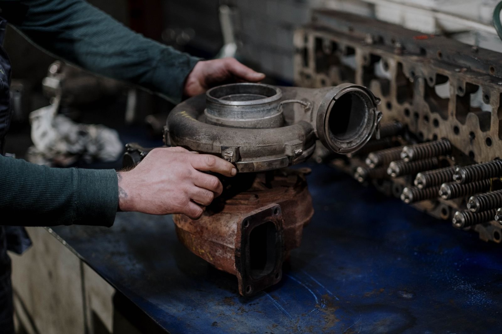 Mechanic holding a diesel engine turbocharger during a chiptuning and emissions system repair