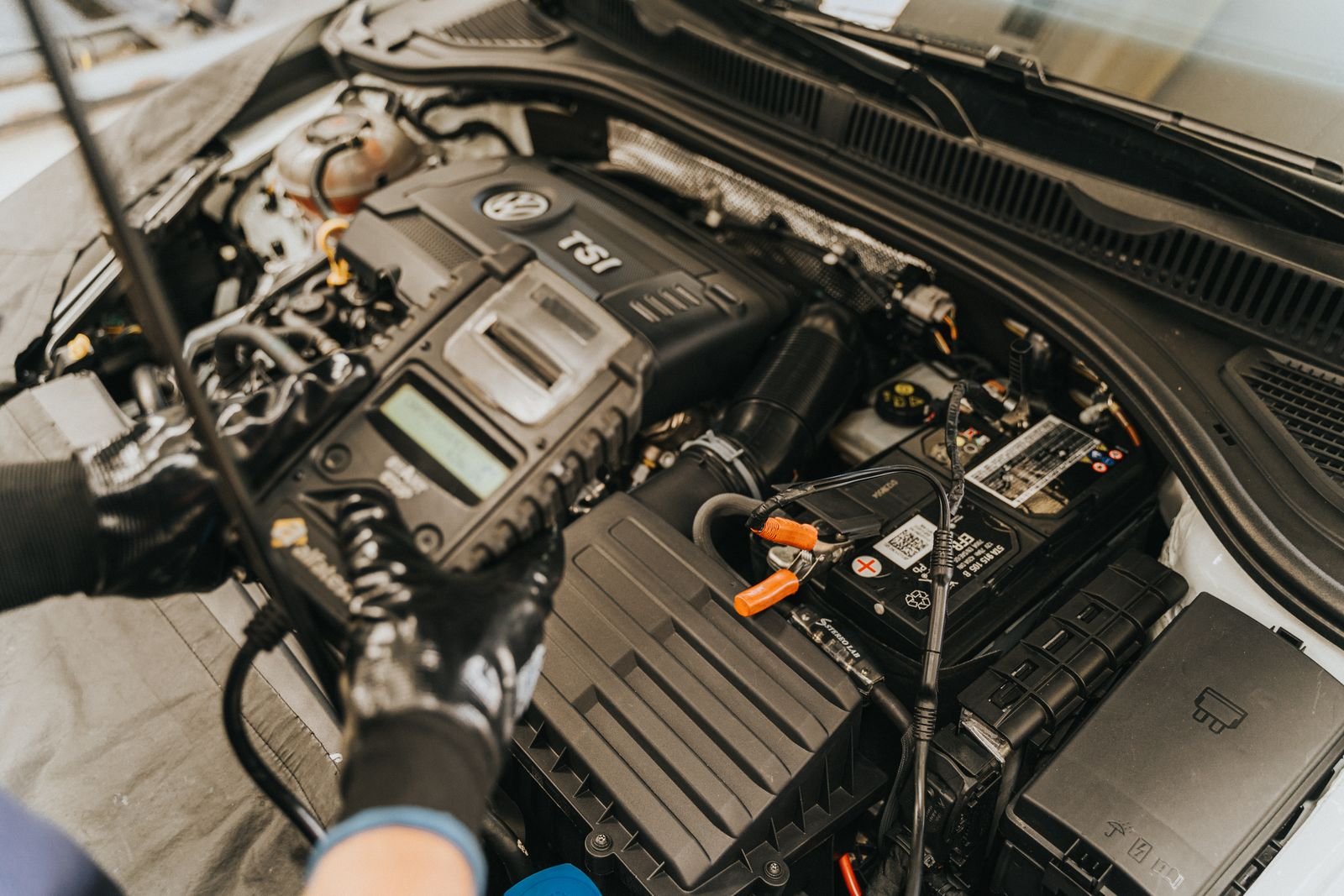 Mechanic running a multi-brand diagnostic scan on a car engine with Delphi or Autocom software